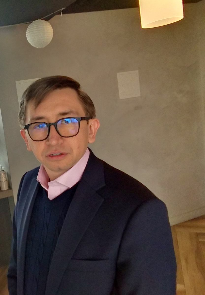Lorenzo in a formal jacket and glasses